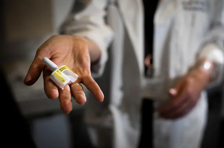 UK First Bridge Clinic's Dr. Michelle Lofwall holds up a dose of life-saving naloxone nasal spray. UK Photo | Pete Comparoni