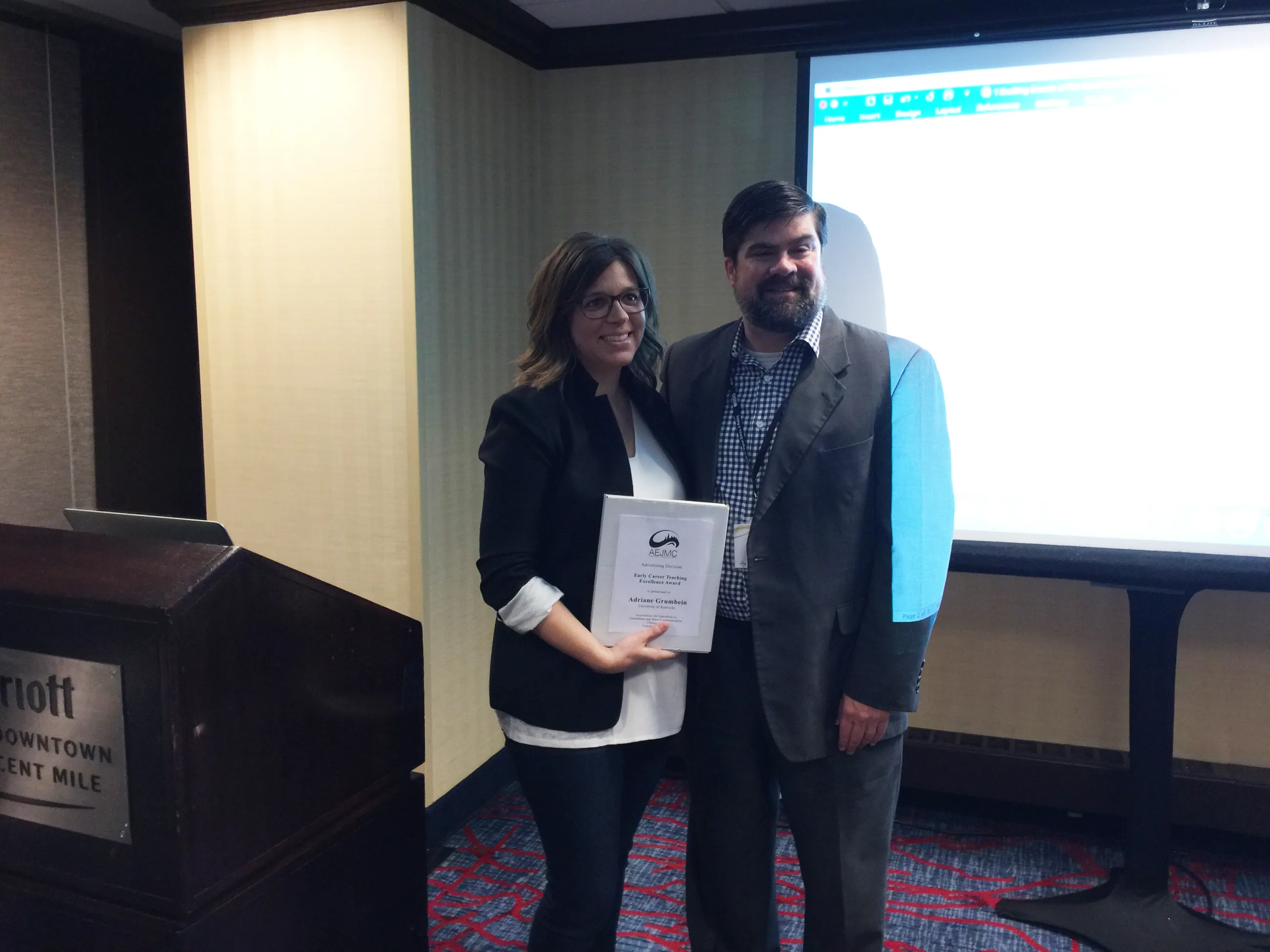 Adriane Grumbein receiving the 2017 Early Career Teaching Excellence Award at the Association of Education in Journalism and Mass Communication’s (AEJMC) annual conference.