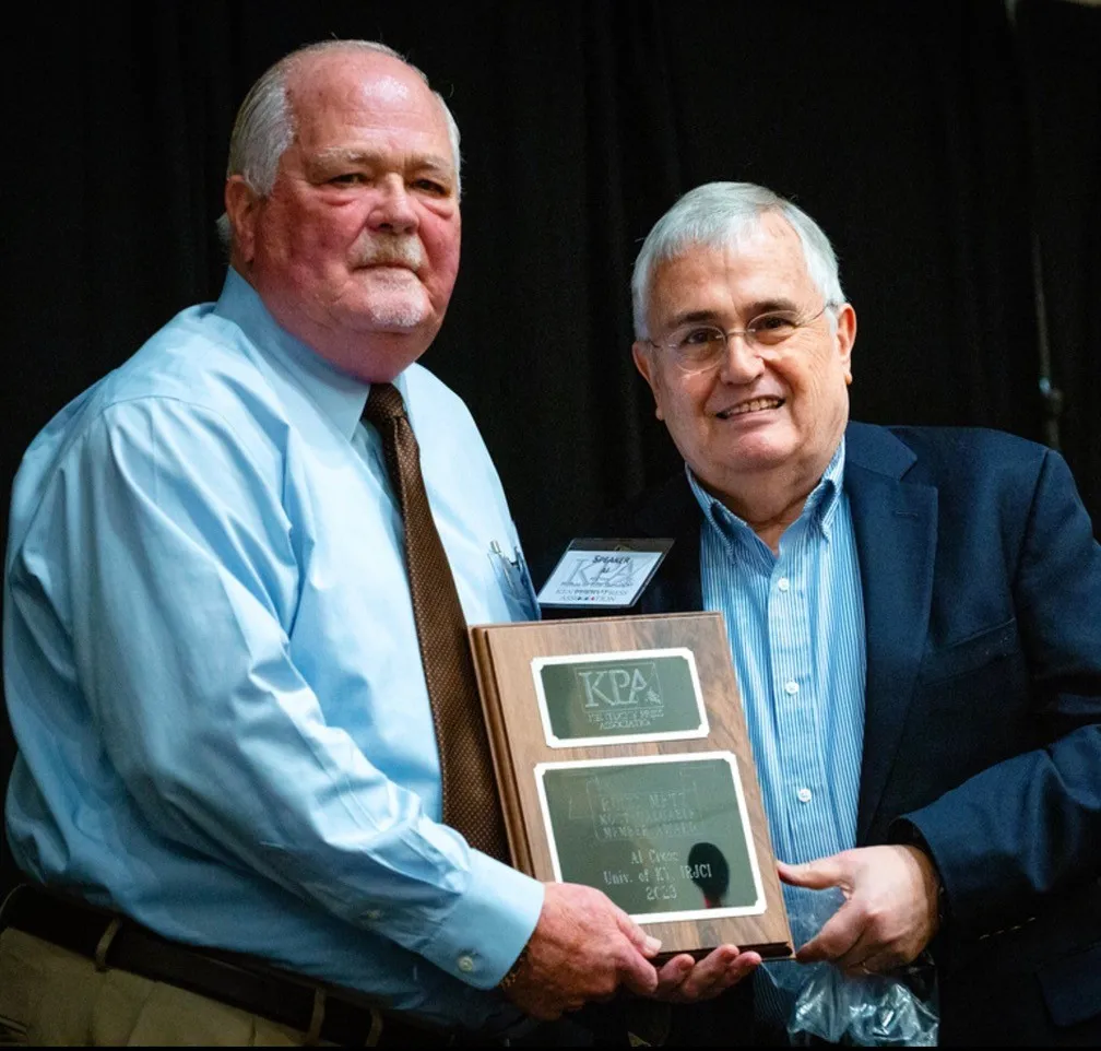 Professor Al Cross (right) is presented with the KPA Most Valuable Member Award by KPA Executive Director David Thompson (left).