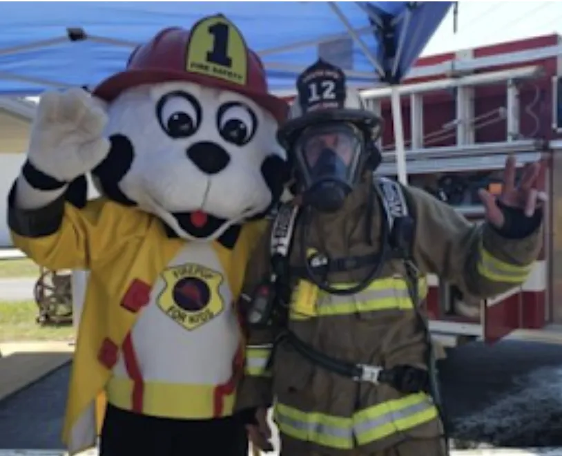 Asst. Fire Chief Michael Moravek with mascot, Fire Pup. (Photo by Jennifer King via the Echo)