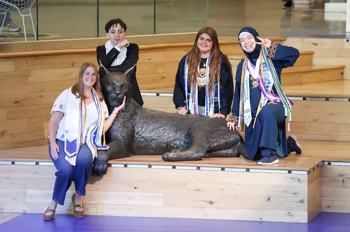 From left: Siena Pilati, Mostafa Mubarak, Carolina Burn and Fatimah Alomar pose with the Bowman Wildcat statue in the Gatton Student Center. Carter Sloss | UK Photo
