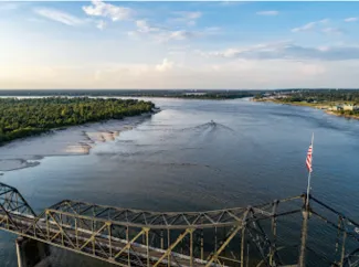 Bridge near Vicksburg, Miss., and a pusher tug headed up the Mississippi River. (Photo by Justin Wilkens, Unsplash)