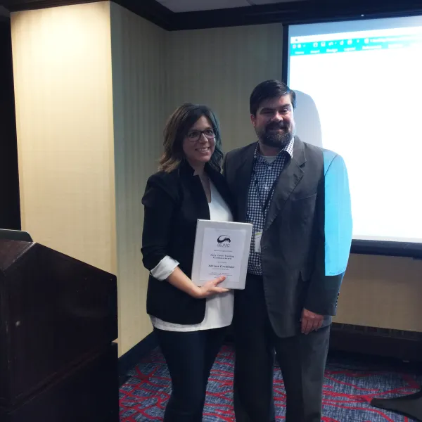 Adriane Grumbein receiving the 2017 Early Career Teaching Excellence Award at the Association of Education in Journalism and Mass Communication’s (AEJMC) annual conference.