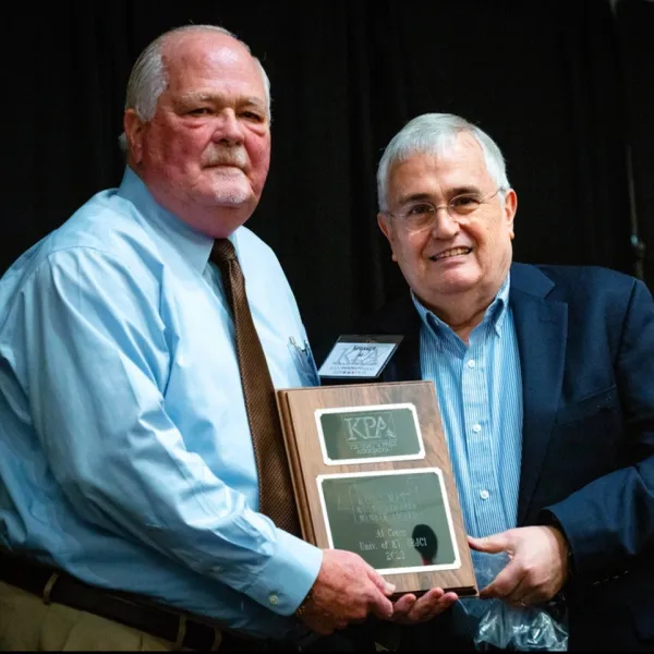 Professor Al Cross (right) is presented with the KPA Most Valuable Member Award by KPA Executive Director David Thompson (left).